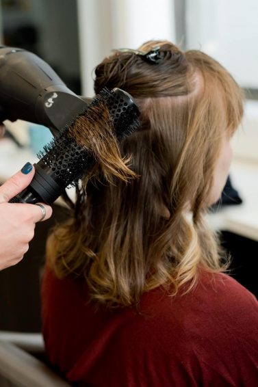 woman getting her hair styled in the salon