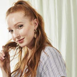 Woman touching her long red hair smiling