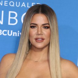 Khloe Kardashian with long straight light blonde hair with darker roots.