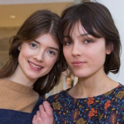 two brunette models backstage at a runway show